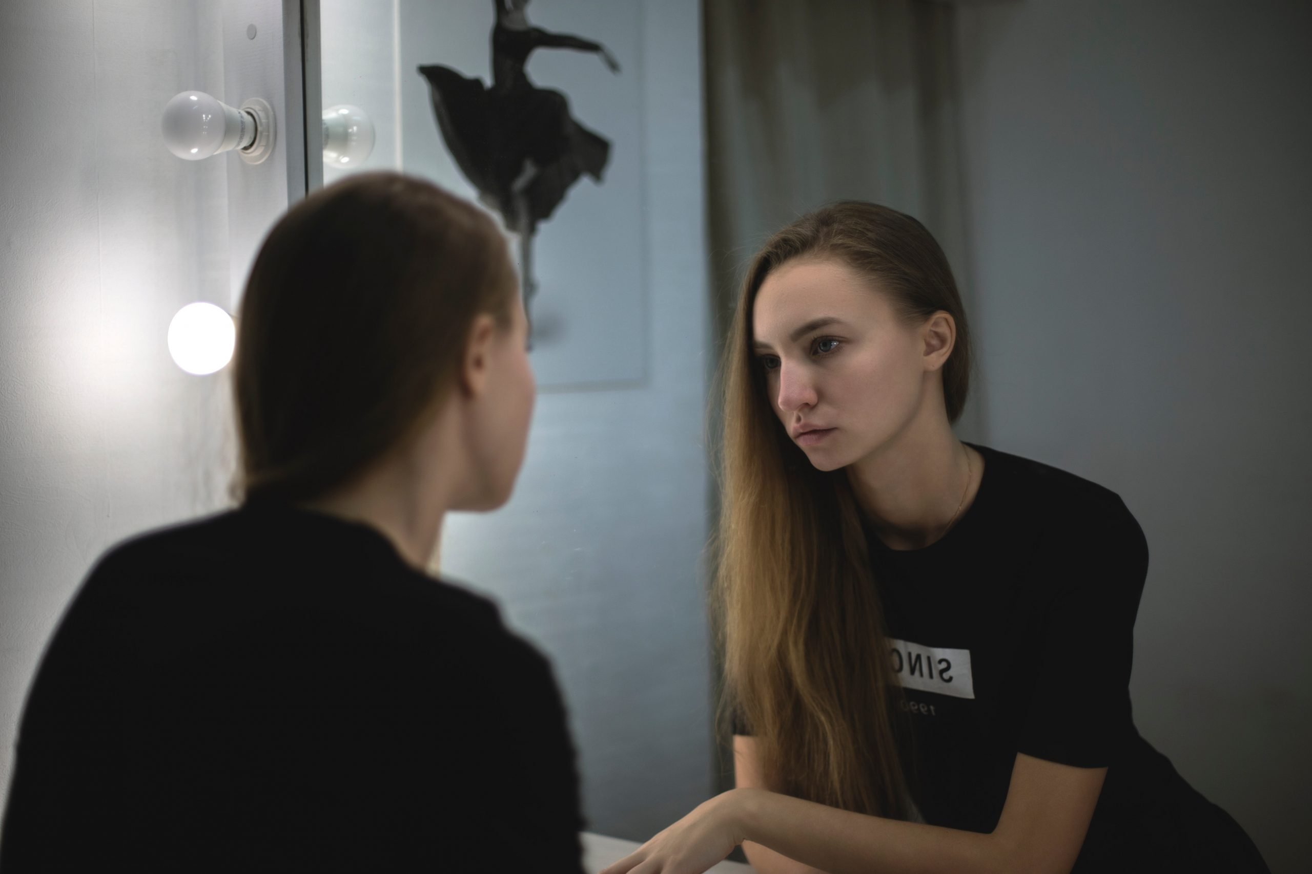 woman facing mirror